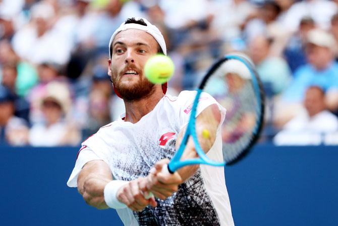 Portugal's Jaoa Sousa returns the ball his fourth round match against Novak Djokovic