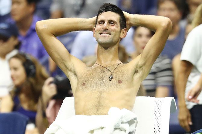 Novak Djokovic relaxes while John Millman heads for an unscheduled break during their US Open quarter-final on Wednesday 
