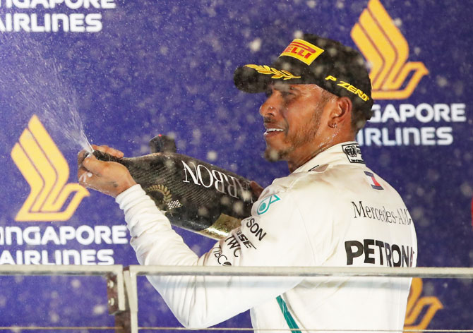 Mercedes' Lewis Hamilton celebrates on the podium after winning the Singapore F1 GP on Sunday
