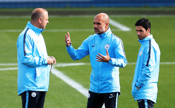 Manchester City manager Pep Guardiola (centre) with co-assistant coach Mikel Arteta (right) and Rodolfo Borrell during a training session