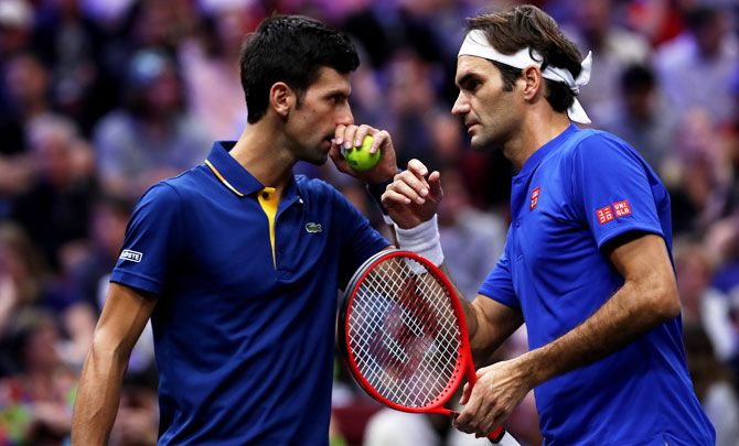 Team Europe's Roger Federer and Novak Djokovic discuss tactics during their match against Team World's Jack Sock and Kevin Anderson during their Men's Doubles match on day one of the 2018 Laver Cup at the United Center in Chicago on Thursday