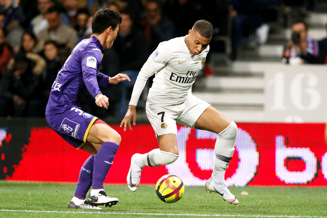 Paris St Germain's Kylian Mbappe in action with Toulouse's Gen Shoji during their Ligue 1 match at Stadium Municipal de Toulouse, Toulouse, France, on Sunday 