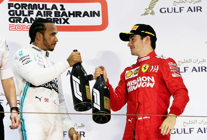 Mercedes' Lewis Hamilton celebrates on the podium with third-placed Ferrari's Charles Leclerc