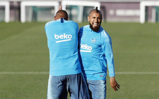 FC Barcelona's Kevin-Prince Boateng and Arturo Vidal share a light moment during a practice session on Monday