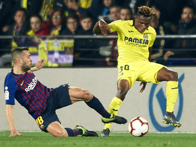 Villarreal's Samuel Chimerenka Chukweze is challenged by Barcelona's Jordi Alba