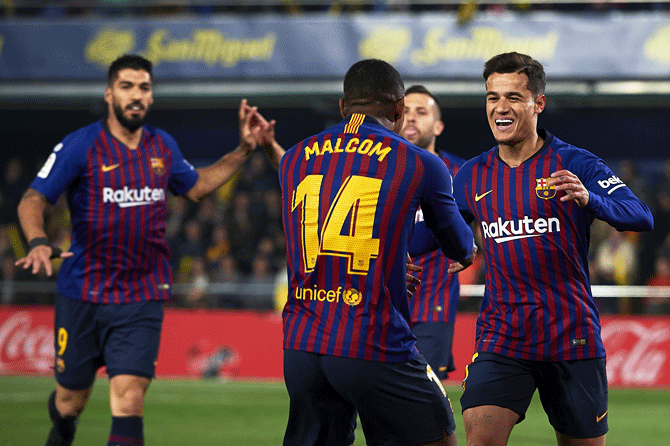 Barcelona's Philippe Coutinho celebrates teammate Malcom after the team's first goal at Estadio de la Ceramica in Villareal, Spain, on Tuesday