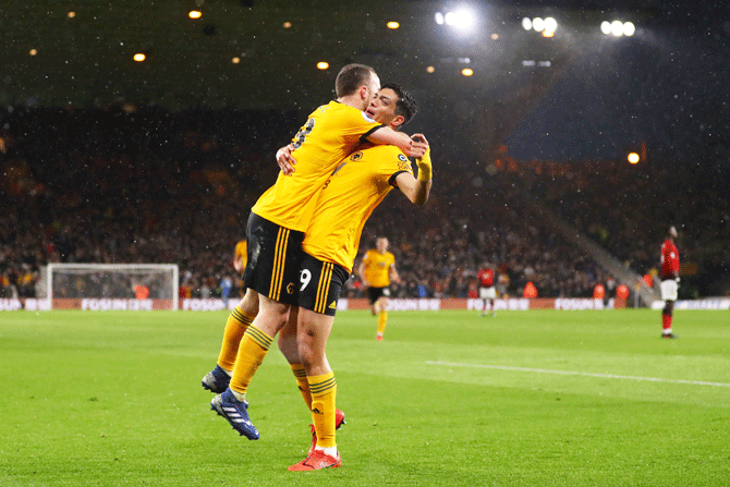 Wolverhampton Wanderers' Diogo Jota celebrates with teammate Raul Jimenez after scoring his team's first goal during their English Premier League match at Molineux in Wolverhampton, United Kingdom, on Tuesday