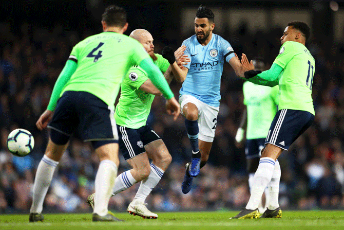 Manchester City's Riyad Mahrez is challenged by Cardiff City's Aron Gunnarsson and Josh Murphy