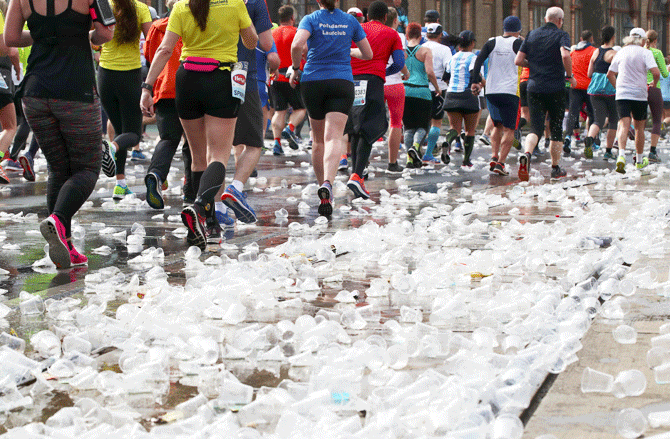 Runners pass along discarded cups at a refreshment point during the Vienna City Marathon in Vienna, Austria, on Sunday, April 7