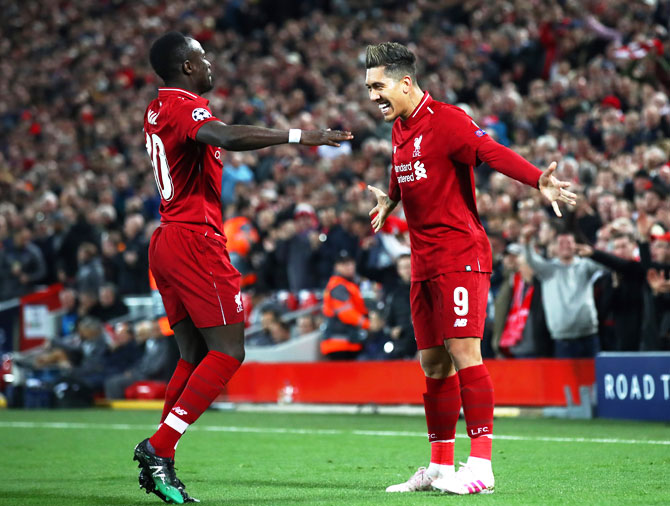 Liverpool FC's Roberto Firmino celebrates with teammate Sadio Mane after scoring the second goal against Porto during their UEFA Champions League quarter-final first leg match at Anfield in Liverpool, on Tuesday