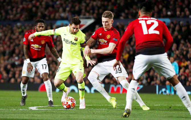 Manchester United's Scott McTominay and Barcelona's Lionel Messi vie for possession during their UEFA Champions League match at Old Trafford on Wednesday
