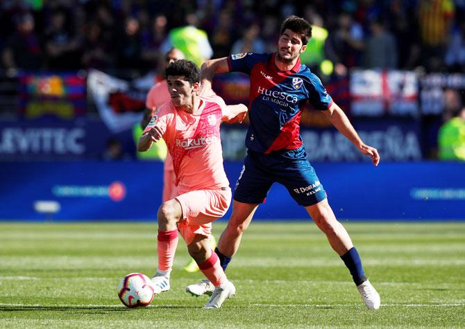 Barcelona's Carles Alena vies with Huesca's Gonzalo Melero during their La Liga match at Estadio El Alcoraz in Huesca on Saturday