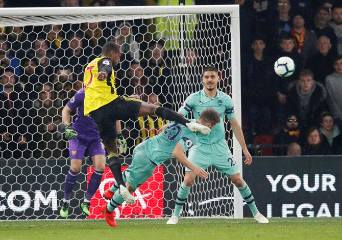Arsenal's Shkodran Mustafi gets hit by Watford's Christian Kabasele as they vie for possession