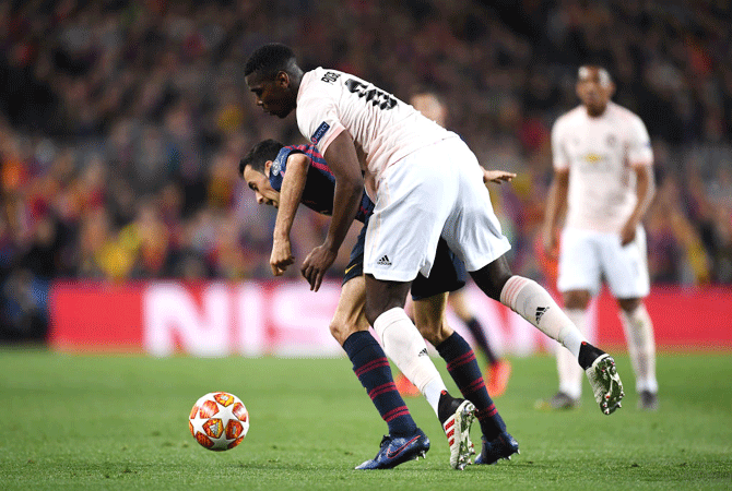 Barcelona's Sergio Busquets and Manchester United's Paul Pogba vie for possession 