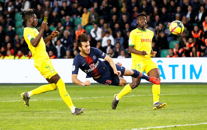Paris St Germain's Metehan Guclu is air-bound as he vies for possession