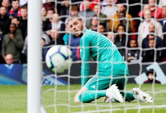 Chelsea's Marcos Alonso scores the equaliser as Manchester United's David de Gea looks on during their EPL match at Old Trafford in Manchester on Sunday