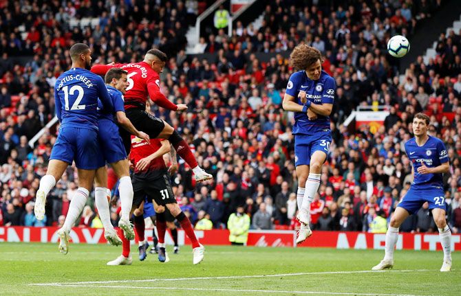 Manchester United's Marcos Rojo heads at goal past airborne Chelsea's David Luiz during their EPL match on Sunday
