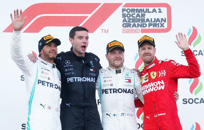 Mercedes' Valtteri Bottas celebrates winning the race with Mercedes mechanic Stuart Green, second placed Lewis Hamilton and third placed Ferrari's Sebastian Vettel