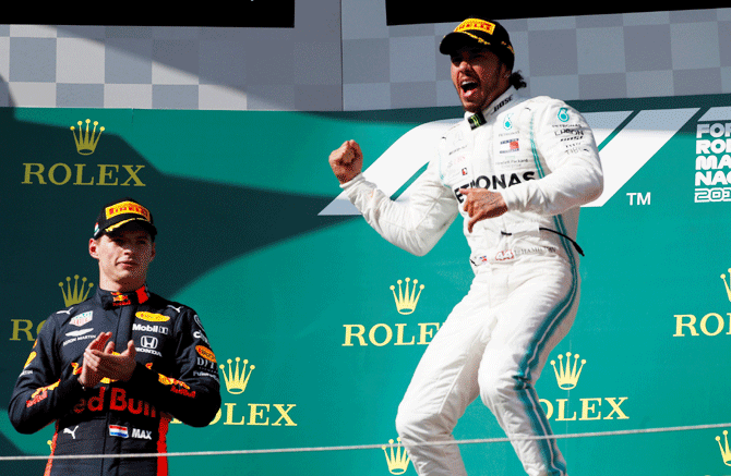 Mercedes' Lewis Hamilton celebrates winning the Hungarian Grand Prix on the podium while Red Bull's Max Verstappen looks on during the Hungaroring, Budapest, Hungary on Sunday