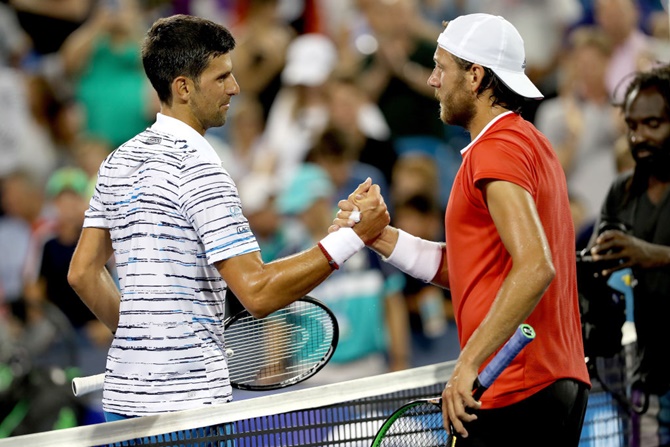 Novak Djokovic is congratulated by Lucas Pouille