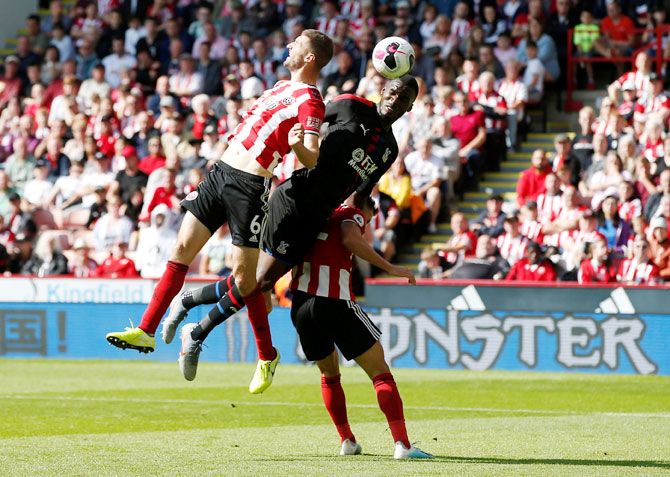 Crystal Palace's Christian Benteke is locked in an aerial battle with Sheffield United's Chris Basham and George Baldock
