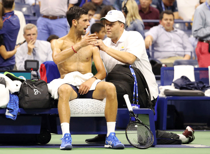 Novak Djokovic is checked by a medical staff during a break in play in his men's singles second round match against Juan Ignacio Londero at the US Open on Wednesday