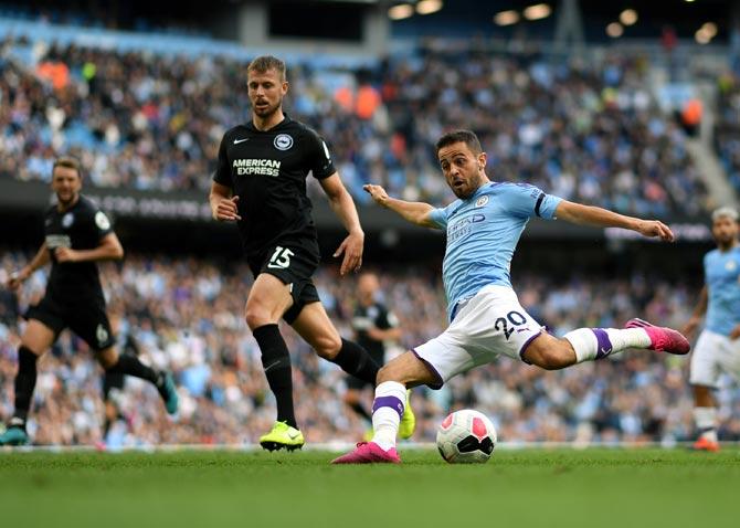 Bernardo Silva of Manchester City shoots past Adam Webster of Brighton and Hove Albion