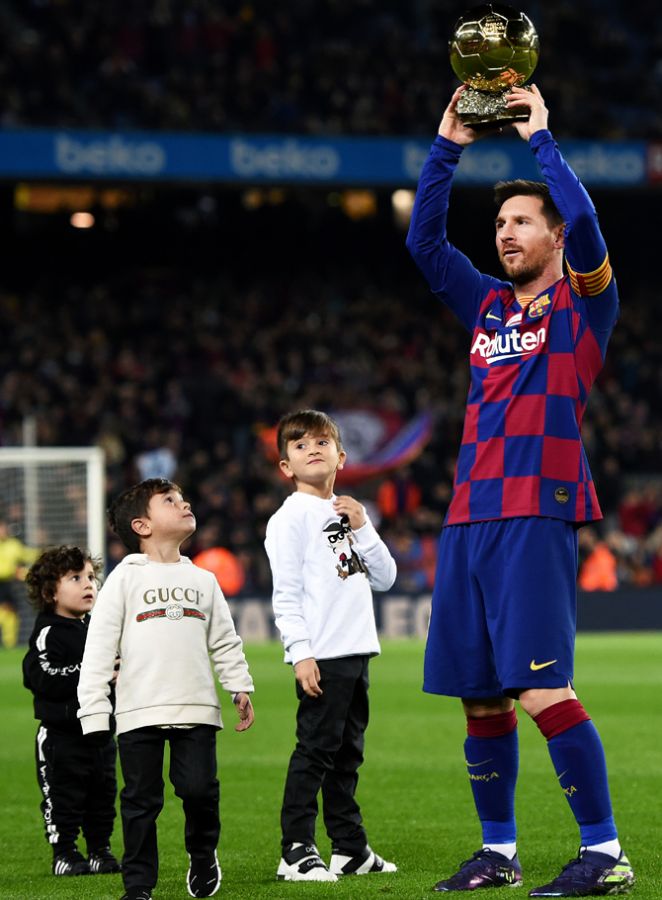 FC Barcelona's Lionel Messi presents his sixth Ballon d'Or trophy to the supporters as his children Ciro Messi Roccuzzo, Thiago Messi Roccuzzo and Mateo Messi Roccuzzo look on, before their La Liga match against Real Mallorca at Camp Nou in Barcelona on Saturday
