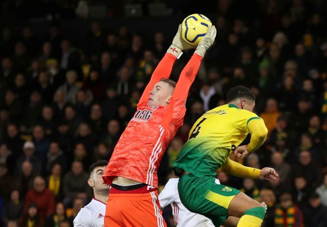 Sheffield United's Dean Henderson collects the ball as a Norwich City player takes evasive action during their match at Carrow Road in Norwich