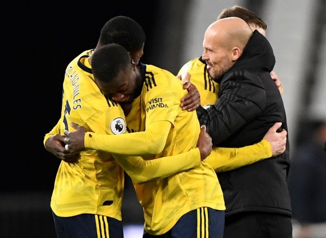 Arsenal's Ainsley Maitland-Niles and Nicolas Pepe celebrate alongside Arsenal interim manager Freddie Ljungberg after their win over West Ham at London Stadium in London on Monday