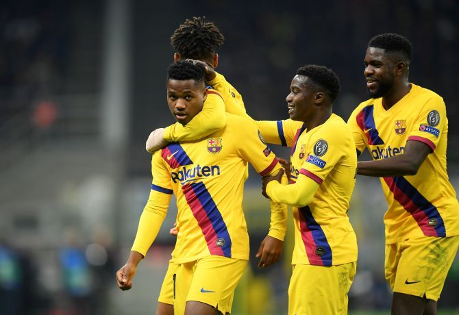 Barcelona's Anssumane Fati celebrates with teammates after scoring their second goal against Inter Milan at San Siro during their Champions League Group F match in Milan, Italy.