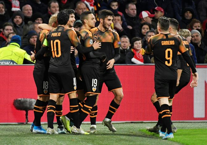 Valencia's Rodrigo celebrates with teammates on netting the opening goal against Ajax Amsterdam in their Champions League Group H match at the Johan Cruijff Arena in Amsterdam, Netherlands