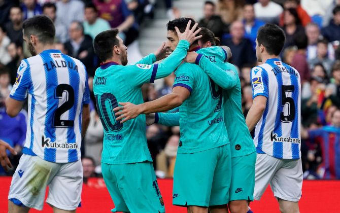 Barcelona's Antoine Griezmann celebrates scoring their first goal with Luis Suarez and Lionel Messi during their La Liga match against Real Sociedad at Anoeta Stadium in San Sebastian, Spain