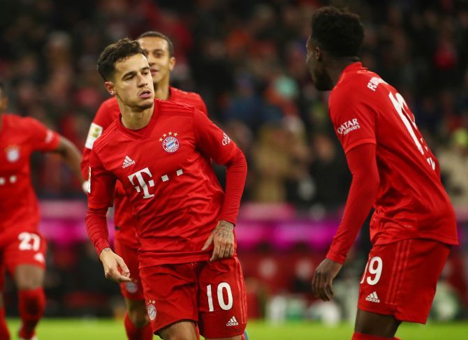 Bayern Munich's Philippe Coutinho celebrates with Alphonso Davies on netting a hat-trick and the team's sixth goal during their  Bundesliga match against Werder Bremen at Allianz Arena in Munich on Saturday