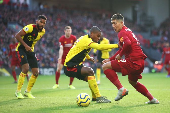 Liverpool's Roberto Firmino crosses the ball under pressure from Watford's Christian Kabasele