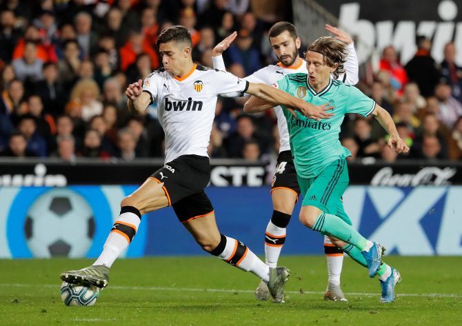 Real Madrid's Luka Modric staves off a challenge from Valencia's Gabriel Paulista as they battle for the ball