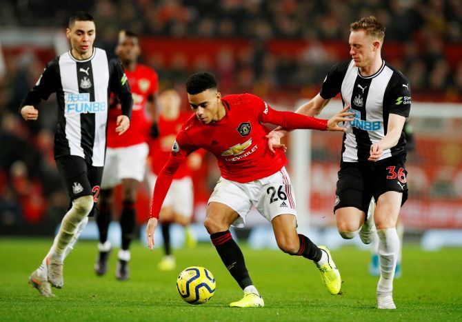 Manchester United's Mason Greenwood fights off a challenge by Newcastle United's Sean Longstaff