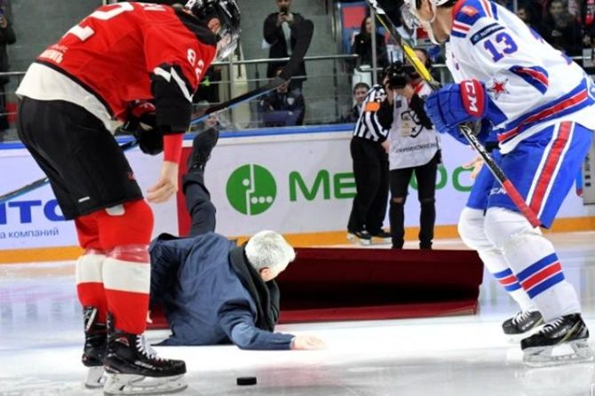 Portuguese soccer manager Jose Mourinho falls down after the ceremonial puck drop, as ice hockey players Evgeny Medvedev and Pavel Datsyuk watch, during the opening a game of Russia’s Kontinental Hockey League near Moscow on Monday February 4