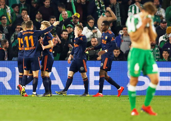 Valencia's Kevin Gameiro celebrates scoring their second goal as Real Betis' Sergio Canales looks dejected on Thursday