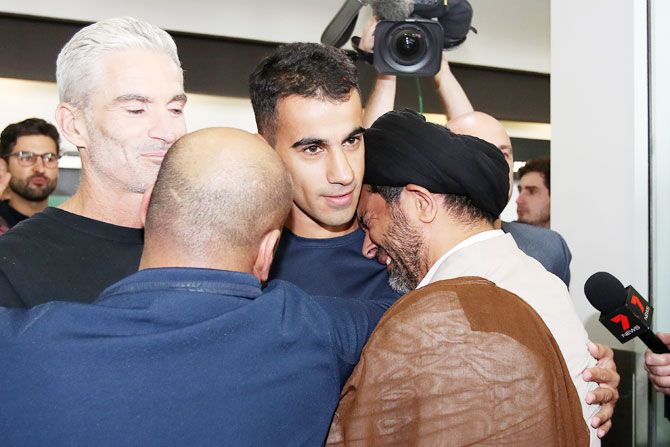 Hakeem al-Araibi receives an emotional welcome by a relative as he arrives in Melbourne with former Australian football captain and commentator Craig Foster at Melbourne Airport in Melbourne, Australia, on Tuesday, February 12. Bahraini refugee Hakeem al-Araibi was detained in November when he arrived in Thailand for his honeymoon, spending more than two months in jail while fighting extradition to Bahrain. Al-Araibi fled his home country in 2014 and was granted refugee status in Australia on the grounds he was persecuted and tortured in the Arabian Gulf state for participating in pro-democracy rallies