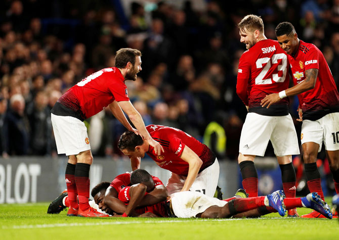 Manchester United players celebrate with Paul Pogba after he scoring their second goal against Chelsea in their FA Cup Fifth Round match at Stamford Bridge in London on Monday