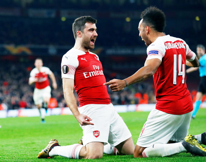 Arsenal's Sokratis Papastathopoulos celebrates with Pierre-Emerick Aubameyang after scoring their third goal against BATE Borisov in their Round of 32 second leg match at Emirates Stadium in London on Thursday