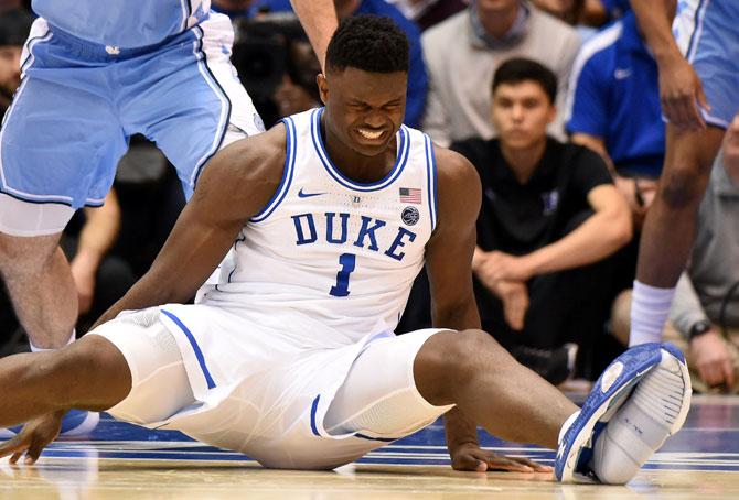 Duke Blue Devils forward Zion Williamson (1) reacts after falling as his shoe splits at the sole, during the first half against the North Carolina Tar Heels at Cameron Indoor Stadium on Wednesday, February 20