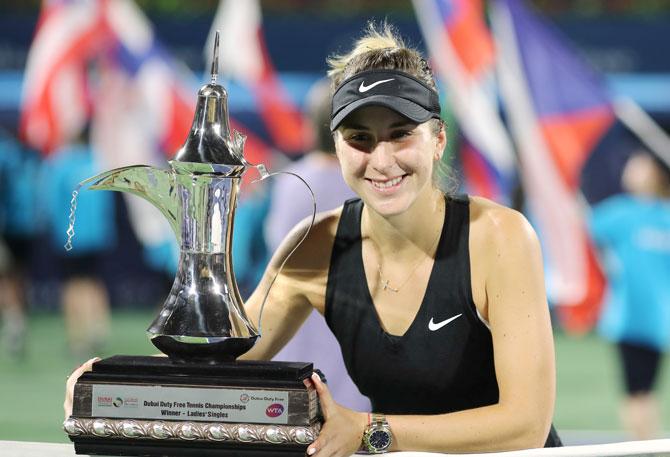 Switzerland's Belinda Bencic celebrates with a trophy after winning the Dubai Tennis Championship against Czech Republic's Petra Kvitova at the Dubai Duty Free Tennis Stadium, Dubai, United Arab Emirates, on Saturday