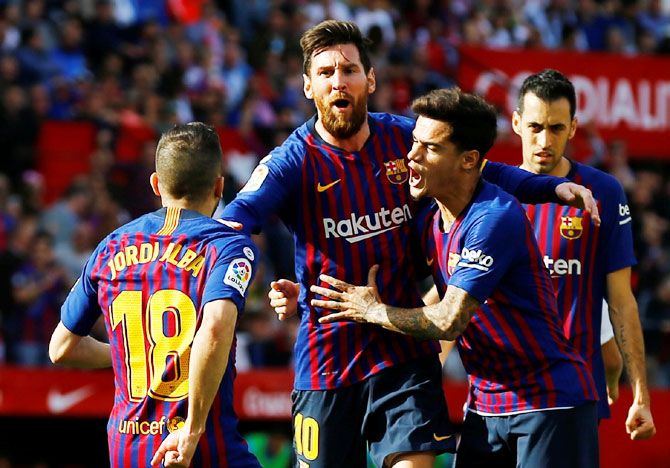 Barcelona's Lionel Messi celebrates with team mates after scoring their first goal against Sevilla on Saturday