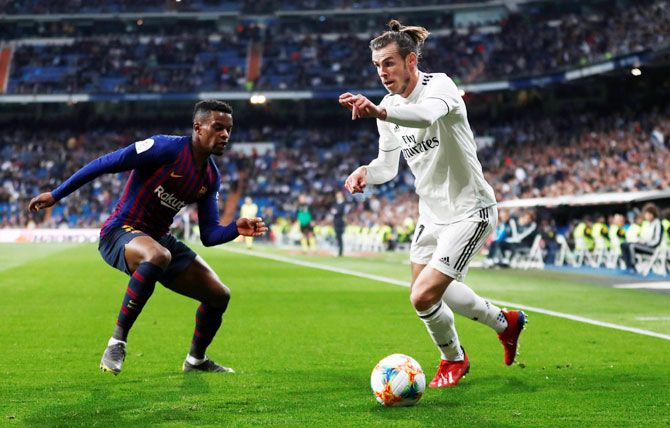 Real Madrid's Gareth Bale is challenged by Barcelona's Nelson Semedo