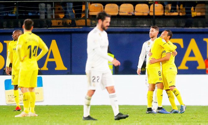 Villarreal's Santi Cazorla celebrates with a teammate as Real Madrid players look dejected after the match
