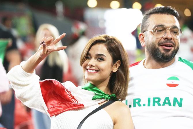 An Iran fan awaits the start of the match against Yemen on Monday