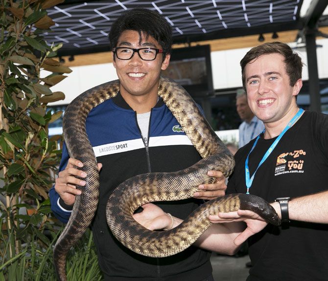 Hyeon Chung is all smiles with a snake coiled around his neck