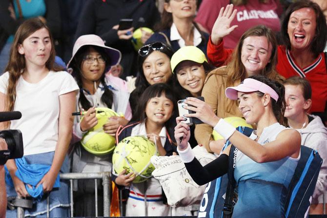 Spain's Garbine Muguruza takes a selfie for fans after her third round match against Switzerland's Timea Bacsinszky on Saturday